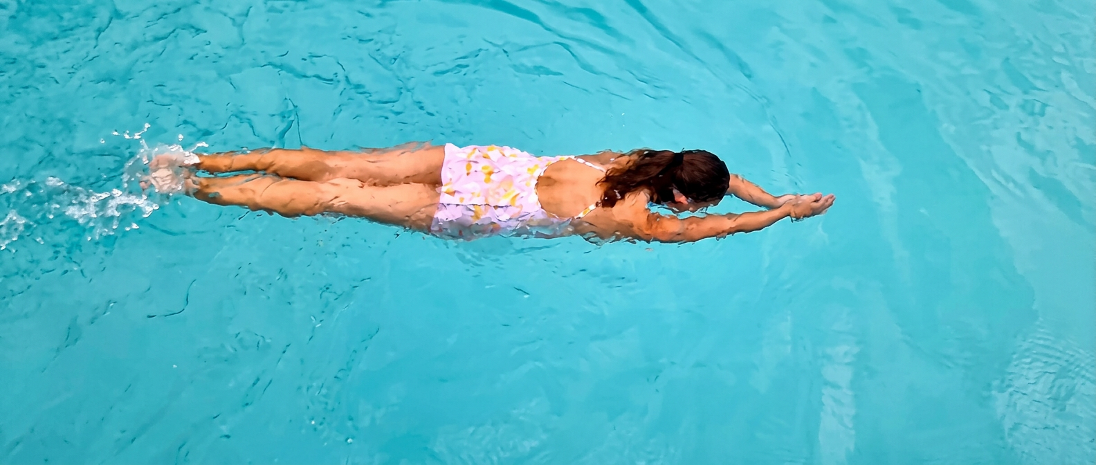 Zwemmer in pijlhouding die soepel over het water glijdt tijdens een zwemles